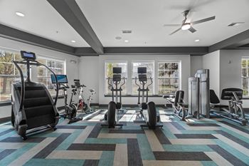 A gym with a variety of equipment including treadmills, stationary bikes, and weight machines.